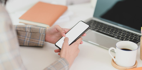 Young businesswoman holding her blank screen smartphone