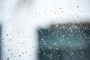 Raindrops on the glass. Drops on the window, the window view of the wall