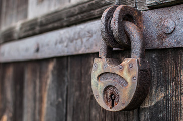 old hanging rusty iron lock on wooden door