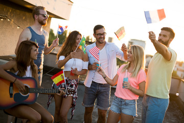 Group of young people having fun at a summertime party, at sunset