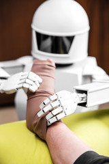 caregiver robot or medical assisted living robot is putting on a compression stocking