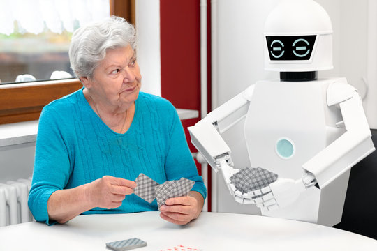 ambient assisted living service robot is playing a card game with a senior adult woman