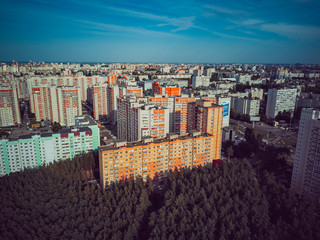 Aerial view to the modern residential buildings. Exterior of high-rise residential building the facades. Residential building surrounded by trees. Skyscrapers in the forest environment