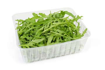 Leaves of fresh arugula in plastic container on white background