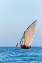 traditional dhow sailing vessel used to transport people goods and commodities heading to sea and...