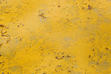 Close-up of a   yellow   wall  painted a very long time and the paint peeled off.  Scary background with smudges of paint