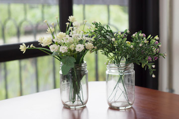 Flowers in glass pots with coffee shop background