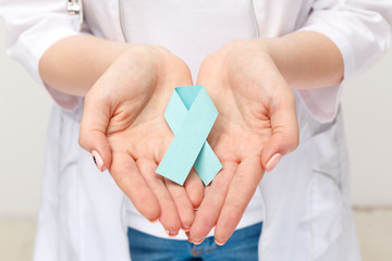 Female hand holding blue ribbon isolated