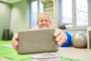 Fototapeta premium Senior Mann mit einem Yogablock für Rehasport