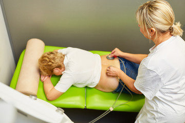 Ärztin behandelt Rücken von Patientin mit Reizstrom