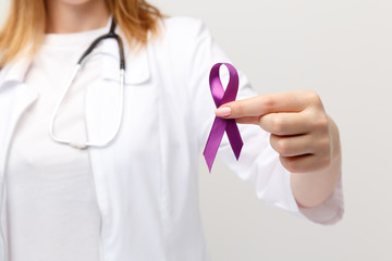 Lymphoma concept. Purple ribbon in the hand isolated