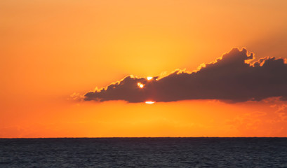 sunrise over sea, clouds and sun obove them