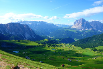 Fototapeta na wymiar Hiking trail leading around peaks of picturesque Seceda Alpine meadows during summer, Ortisei, Dolomites, Northern Italy, Tyrol