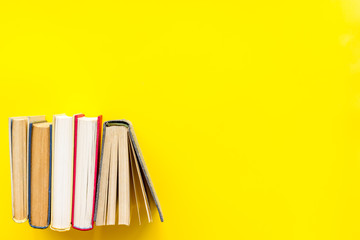 Books on library desk for reading and education on yellow background top view mockup