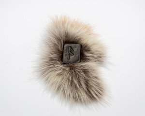 Norse rune Ansuz, isolated on fur and white background. The voice of God. Freedom. Verbal and sound signs. Rune Ansuz is associated with the supreme Scandinavian God Odin.