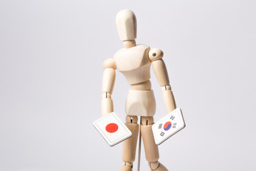 South korea and japanese flag holding a wood joint doll. wooden figure mannequin
