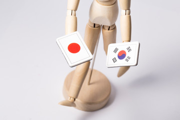South korea and japanese flag holding a wood joint doll. wooden figure mannequin