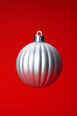 Levitating in air christmas bauble over red  background. Christmas card