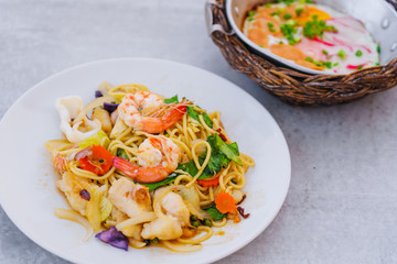 Homemade Spaghetti spicy seafood with prawn and squid on white dish.