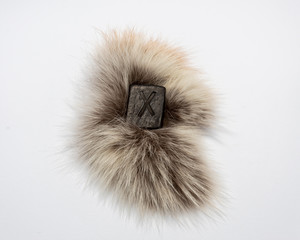 Norse rune Gebo (Gibu), isolated on fur and white background. Gift, balance, harmony, giftedness. The rune is associated with the supreme Scandinavian God Odin.