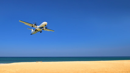 Fototapeta na wymiar Commercial plane landing at phuket on blue sky background, travel concept and business transportation idea