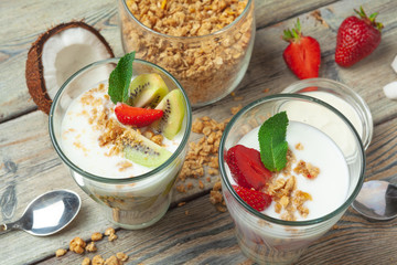 Healthy breakfast with yogurt, berries and granola on wooden table top view