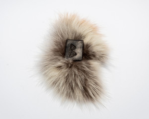 Norse rune Bercana, isolated on fur and white background. Birch, femininity, motherly care and protection. The rune is associated with the Scandinavian Goddess Frigg.