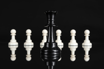 Chess figures on dark black background close up