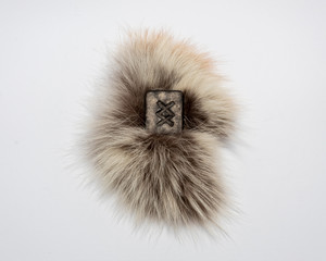 Norse rune Ingwaz, isolated on fur and white background. Seed, potential, energy, fertility. The rune is associated with the Scandinavian god Freyr.