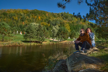 Fototapeta na wymiar couple of tourists by the lake enjoy nature in a Buddhist temple in Quebec on a sunny day