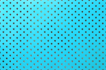 Blue background from metal foil paper with a silver stars pattern