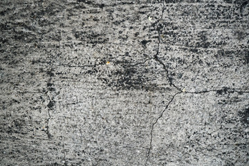 Texture of an old cracked concrete wall. Background image of a worn gray concrete surface