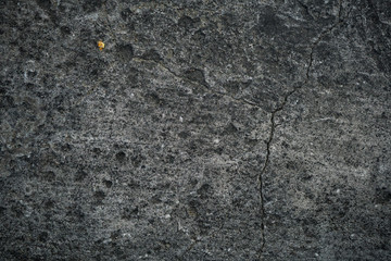 Texture of an old cracked concrete wall. Background image of a worn gray concrete surface