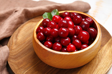 Bowl with ripe sweet cherry on table