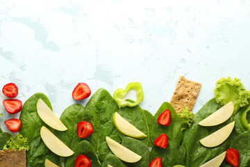 Spinach with strawberry, apple, pepper and crispbread on light background