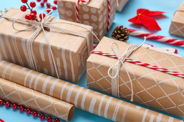 Christmas gift boxes with wrapping paper on color background