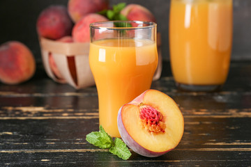 Glass of tasty peach juice on wooden table