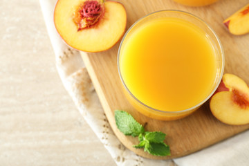 Glass of tasty peach juice on table