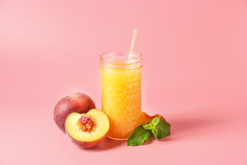 Jar of tasty peach juice on color background