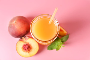 Jar of tasty peach juice on color background