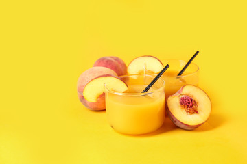 Glasses of tasty peach juice on color background