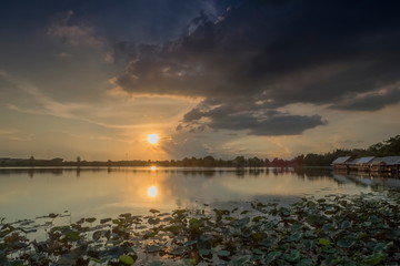 Lake view evening above Lotus lake with cloudy and yellow sun light in the sky background, sunset at Krajub Lake attraction in Ban Pong, Ratchaburi, Thailand.