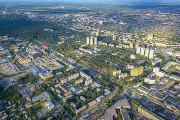 Panoramic aerial view of the city with tall buildings and a shopping center in the middle in Novosibirsk on a sunny afternoon at sunset. Industry and construction.