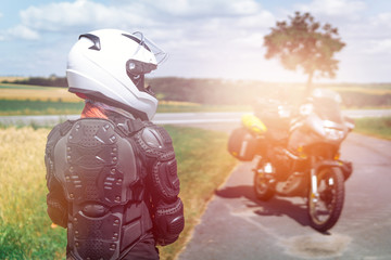 Girl driver portrait, protective equipment, turtle. body armor jacket. Adventure motorbike with bags. motorcycle tour journey. view from the back, light warm tinting, glow. safety first, safe driving