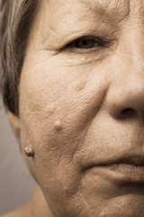 Obraz premium Elderly pensioner female half face portrait closeup