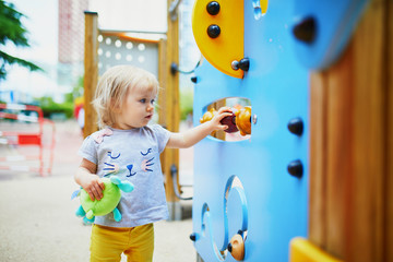 Fototapeta premium Adorable toddler girl having fun on playground