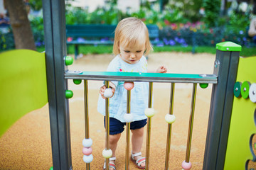 Obraz premium Adorable toddler girl having fun on playground