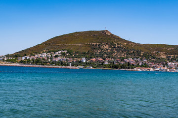 Fototapeta na wymiar Yenifoca waterfront and mountain seen from the beach in Yenifoca. Yenifoca is located in the Izmir province in Turkey.