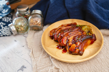 Chinese lacquered pork slices with its caramelized sauce prepared for eating in a wooden plate