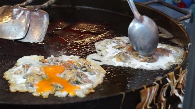 "Oyster omelette or hoi tod" Thaifood in street food Bangkok, Thailand.